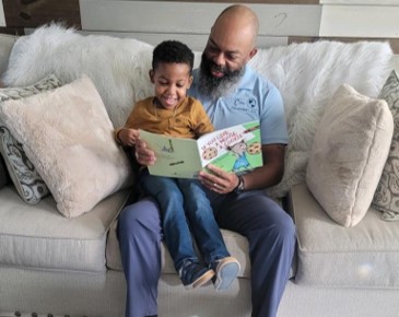 Child sitting on parent lap reading a book